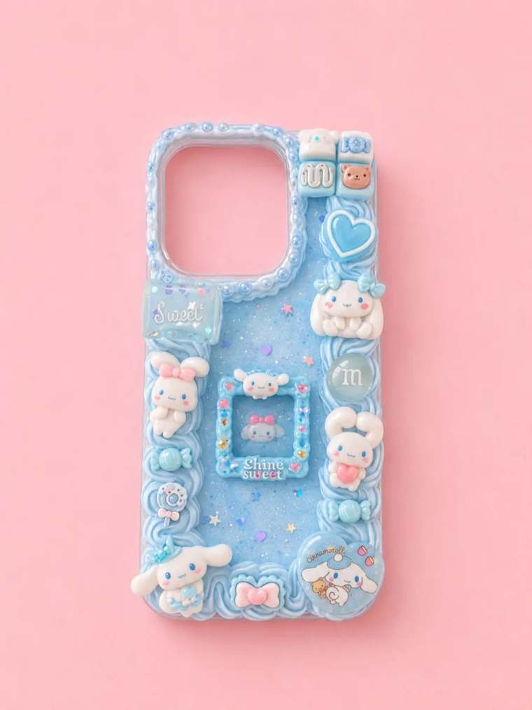 Selbst gestaltete Decoden-Handyhülle in Hellblau mit Sahne-Creme, Glitzer und niedlichen Charms