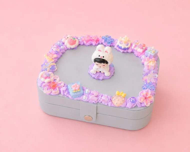 Graues Schmuckkästchen mit selbst gestaltetem Decoden-Rand in Flieder, Blüten-Charms und Hasen-Figur