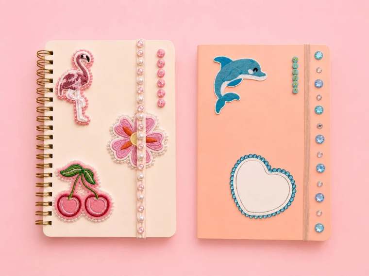 Zwei personalisierte Notizbücher mit aufgenähten Patches – Flamingo und Delfin – Strasssteinen und Namen aus Buchstabenperlen